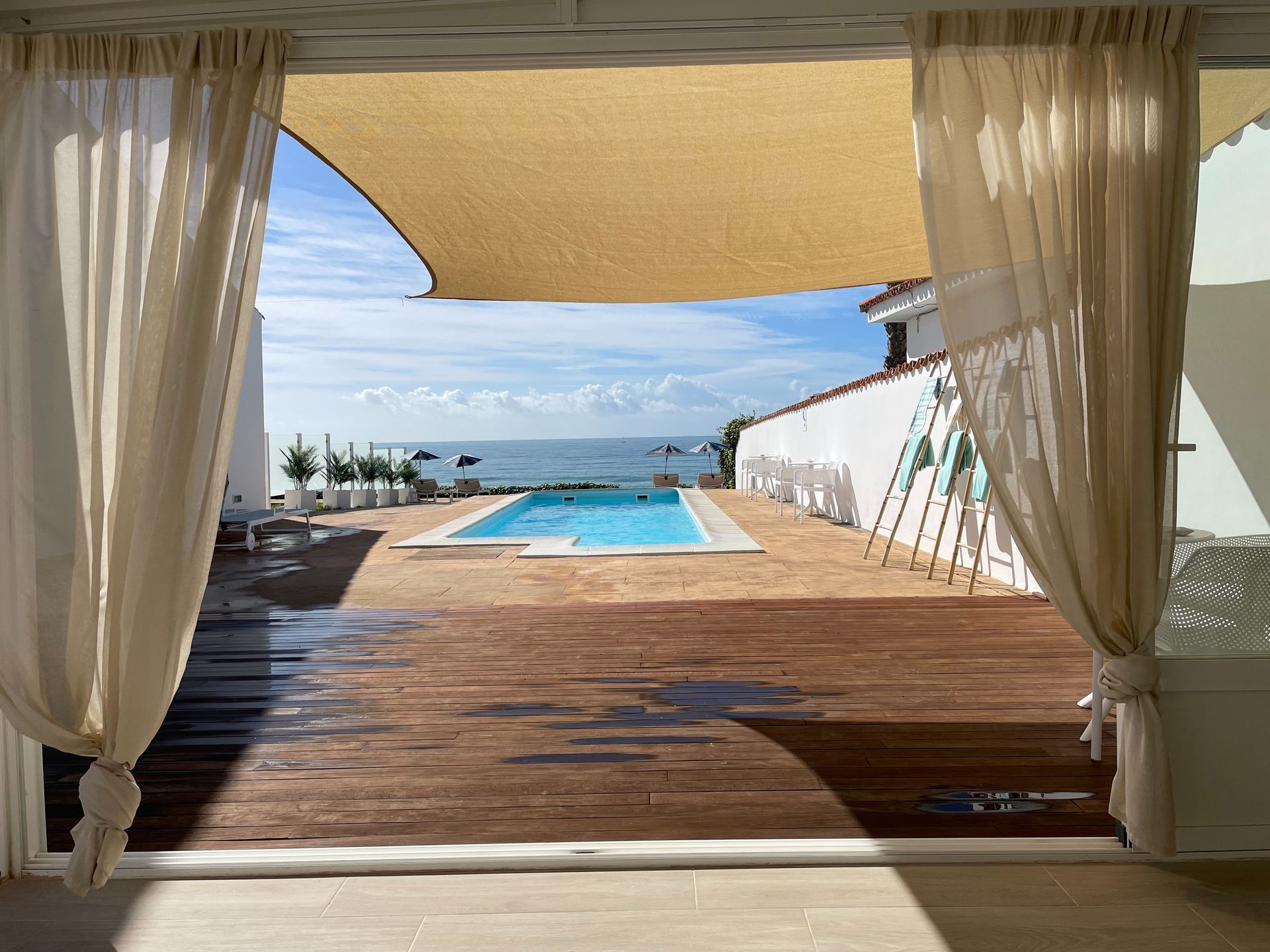 Una vista de una piscina desde el interior de una casa.