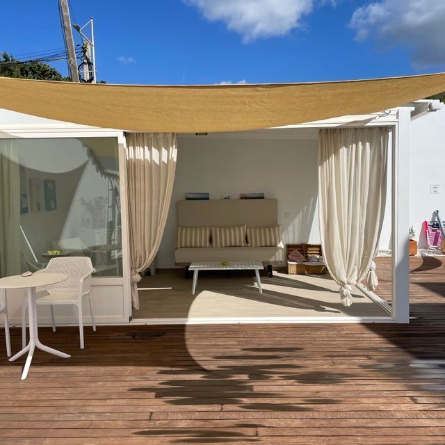 Un patio con un sofá y sillas y una mesa.