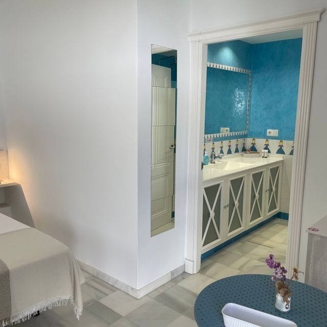 Una habitación con una mesa, un lavabo y un espejo