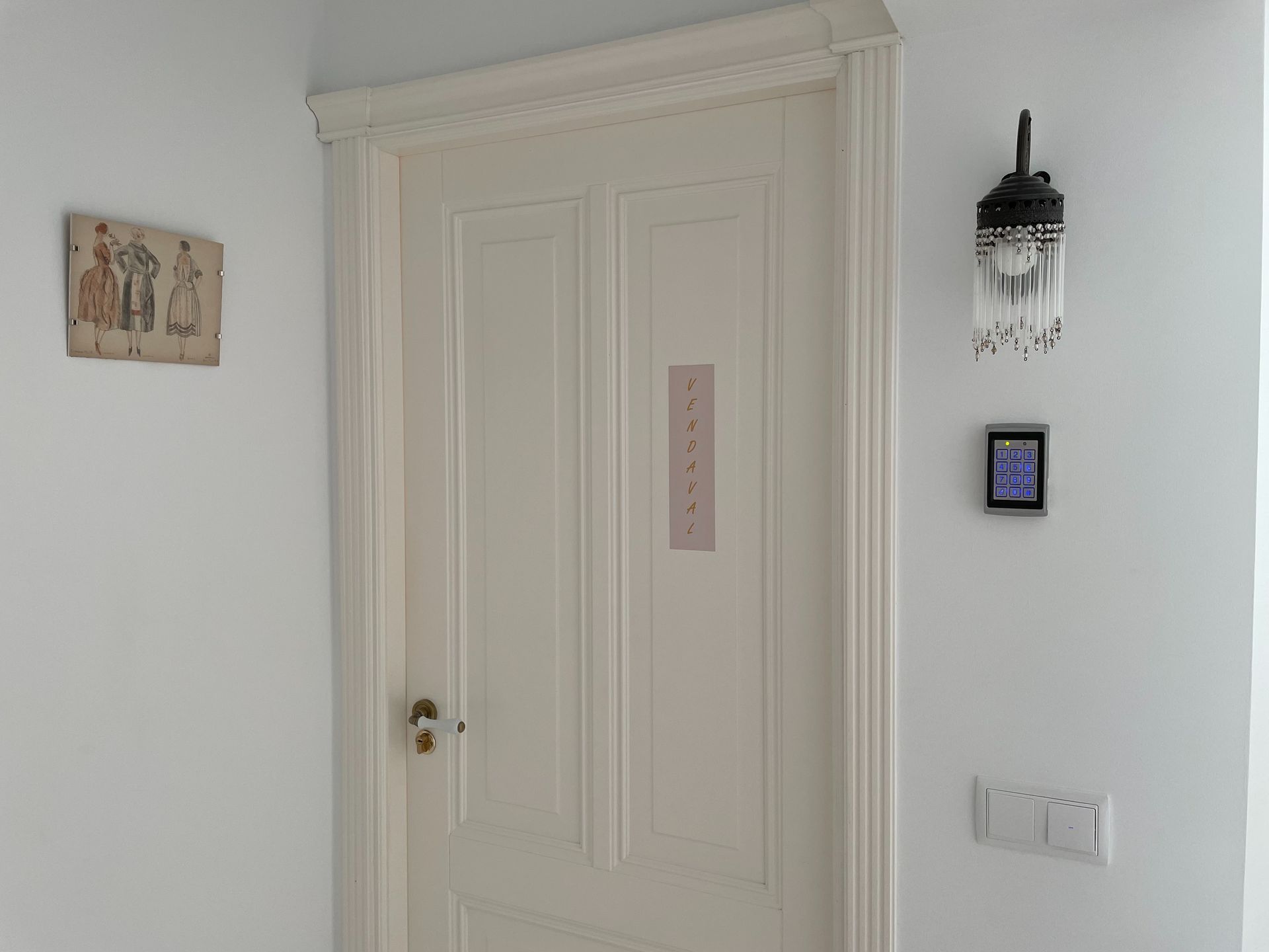 Una puerta blanca con una luz en la pared al lado.