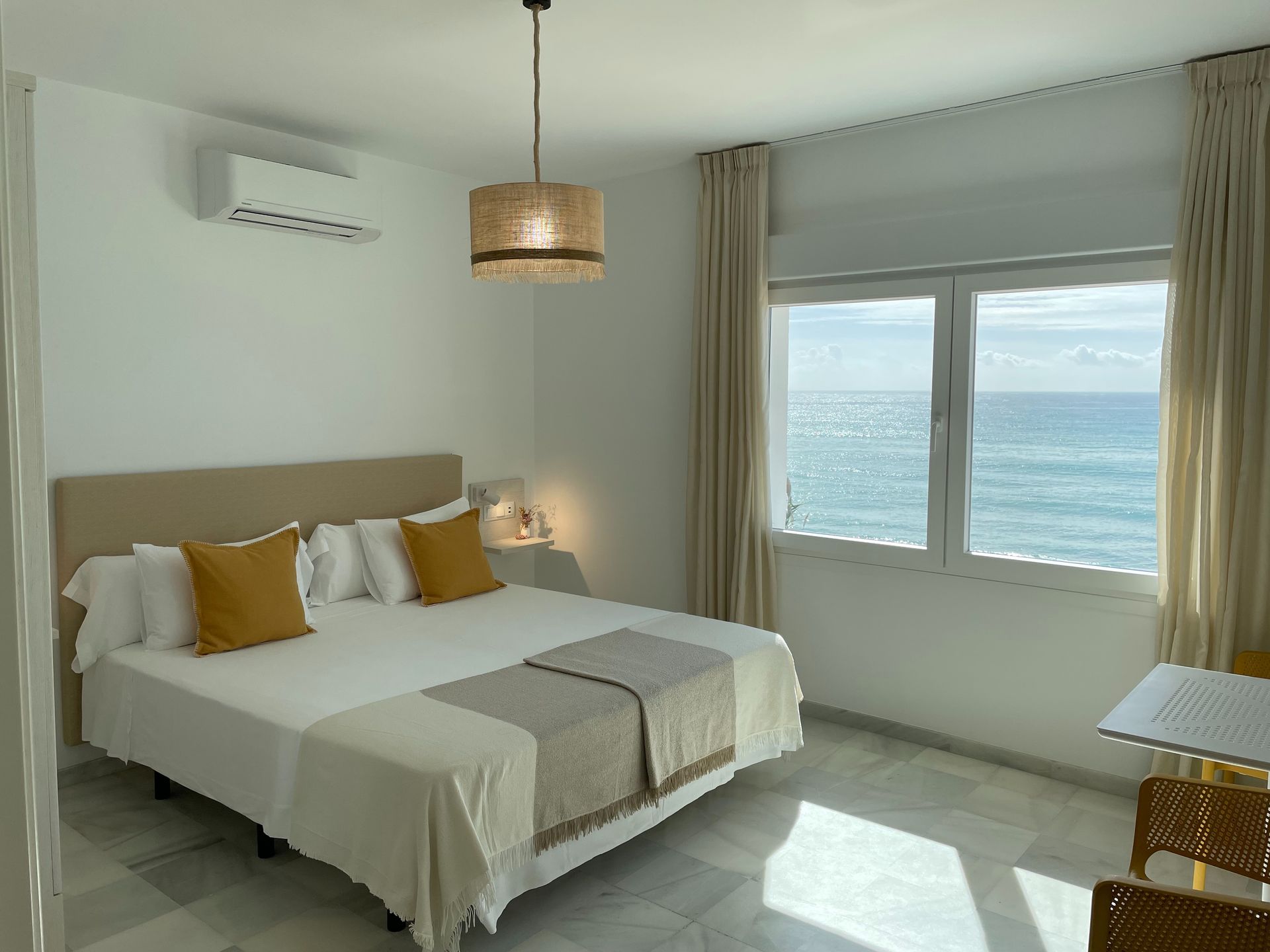 Un dormitorio con una cama grande y vista al mar.