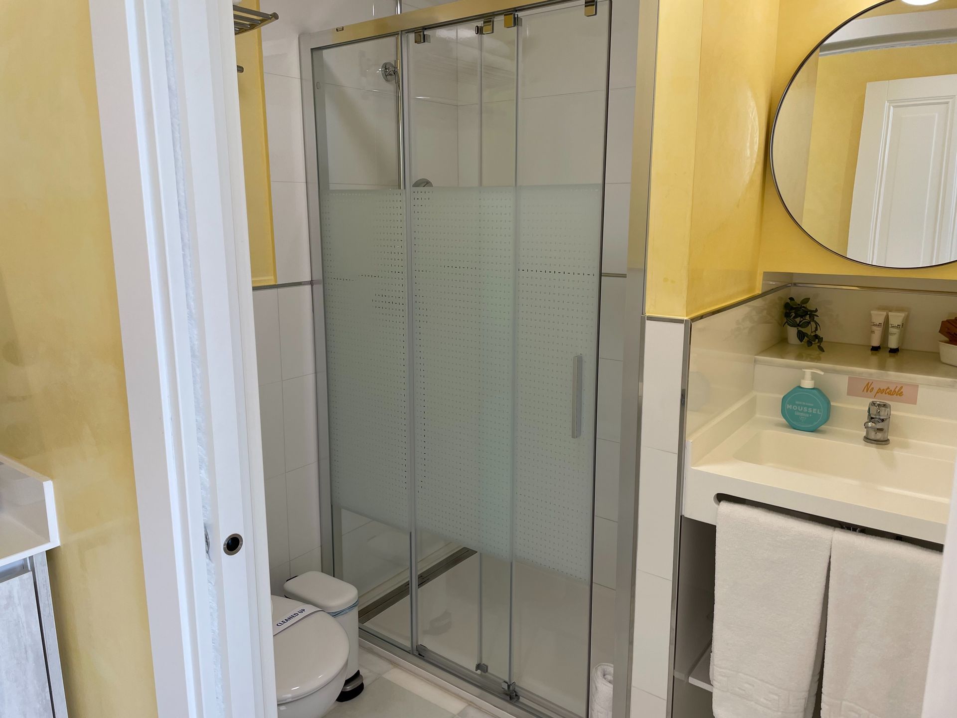 Un baño con inodoro, lavabo, espejo y cabina de ducha.