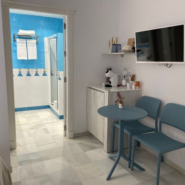 Una habitación con una mesa y sillas y un televisor de pantalla plana.