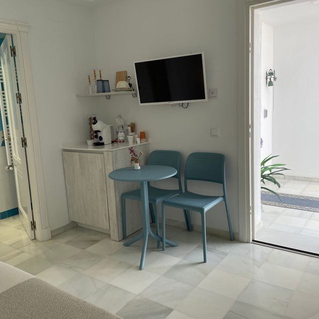 Una habitación con una mesa y sillas y un televisor de pantalla plana.