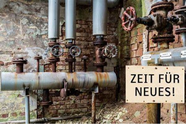 Neben einem Haufen Rohre hängt ein Schild mit der Aufschrift „Zeit für Neues“.