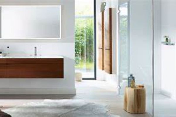 Ein Badezimmer mit Waschbecken, Spiegel und ebenerdiger Dusche.