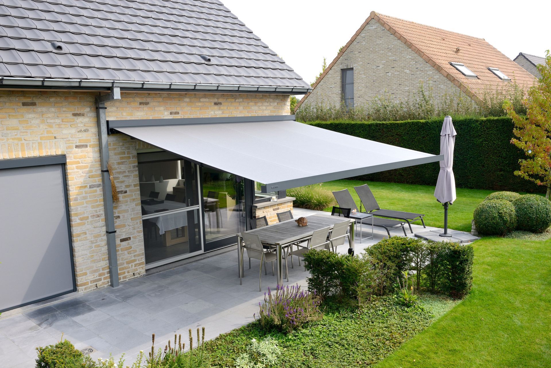 Store banne protégeant une terrasse de jardin chez un particulier