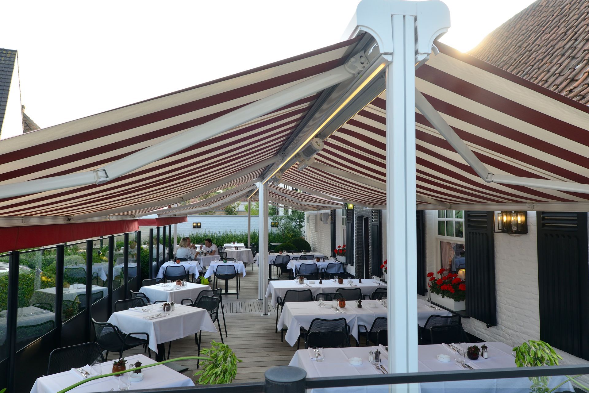 Terrasse d'un restaurant sous des stores bannes à double pente