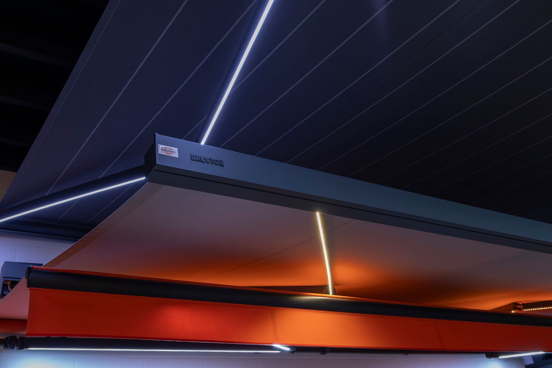 Présentation d'un store banne chez Godstore sous une lumière orangée