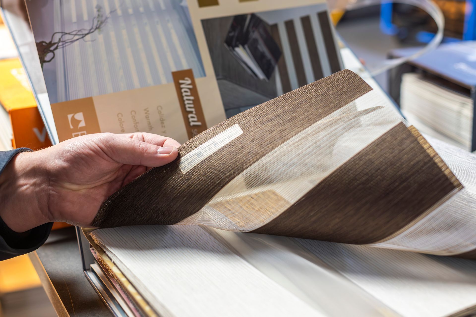 Main soulevant le tissu d'un store intérieur