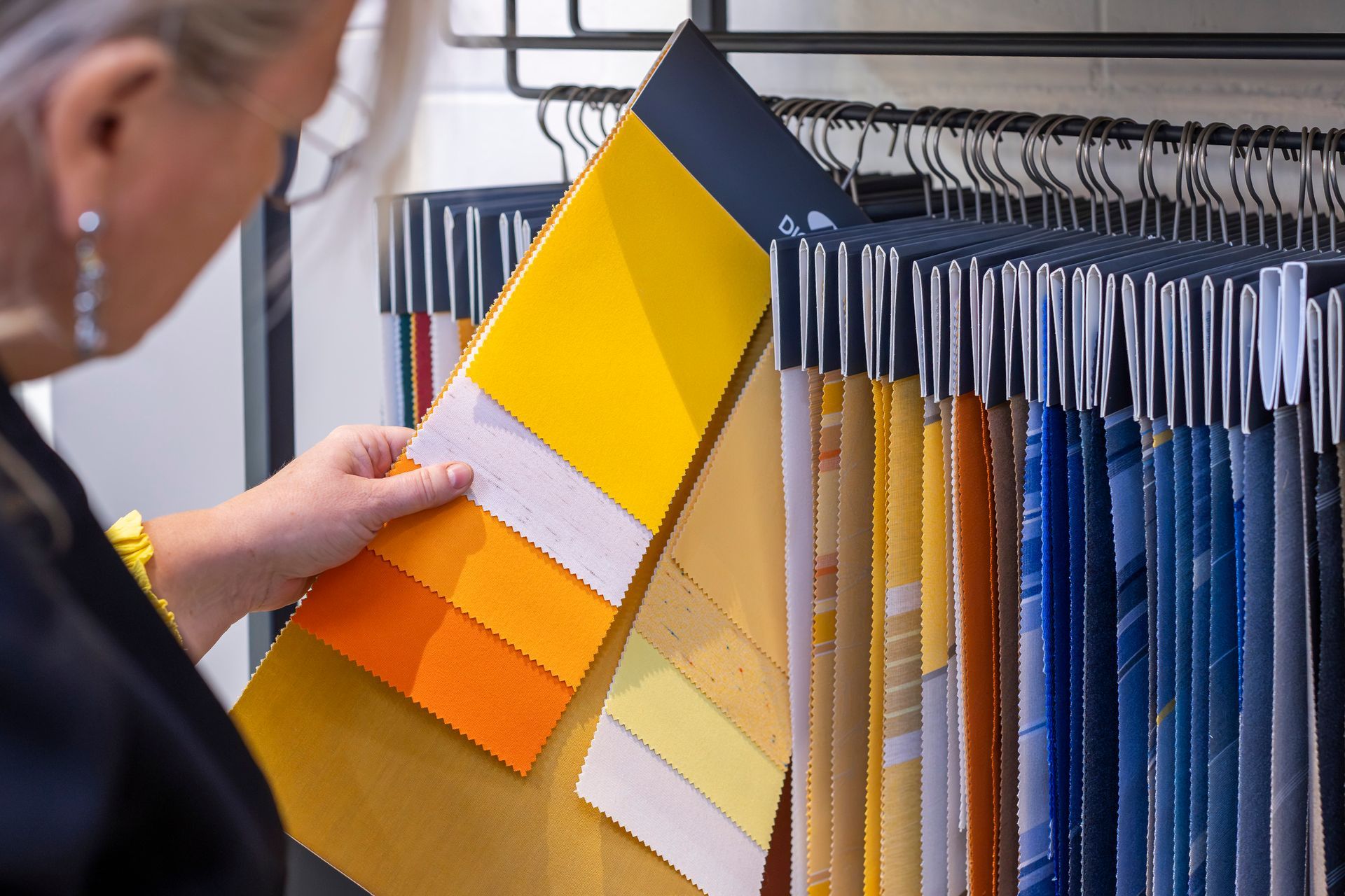 Une personne en train de regarder des échantillons de tissus colorés