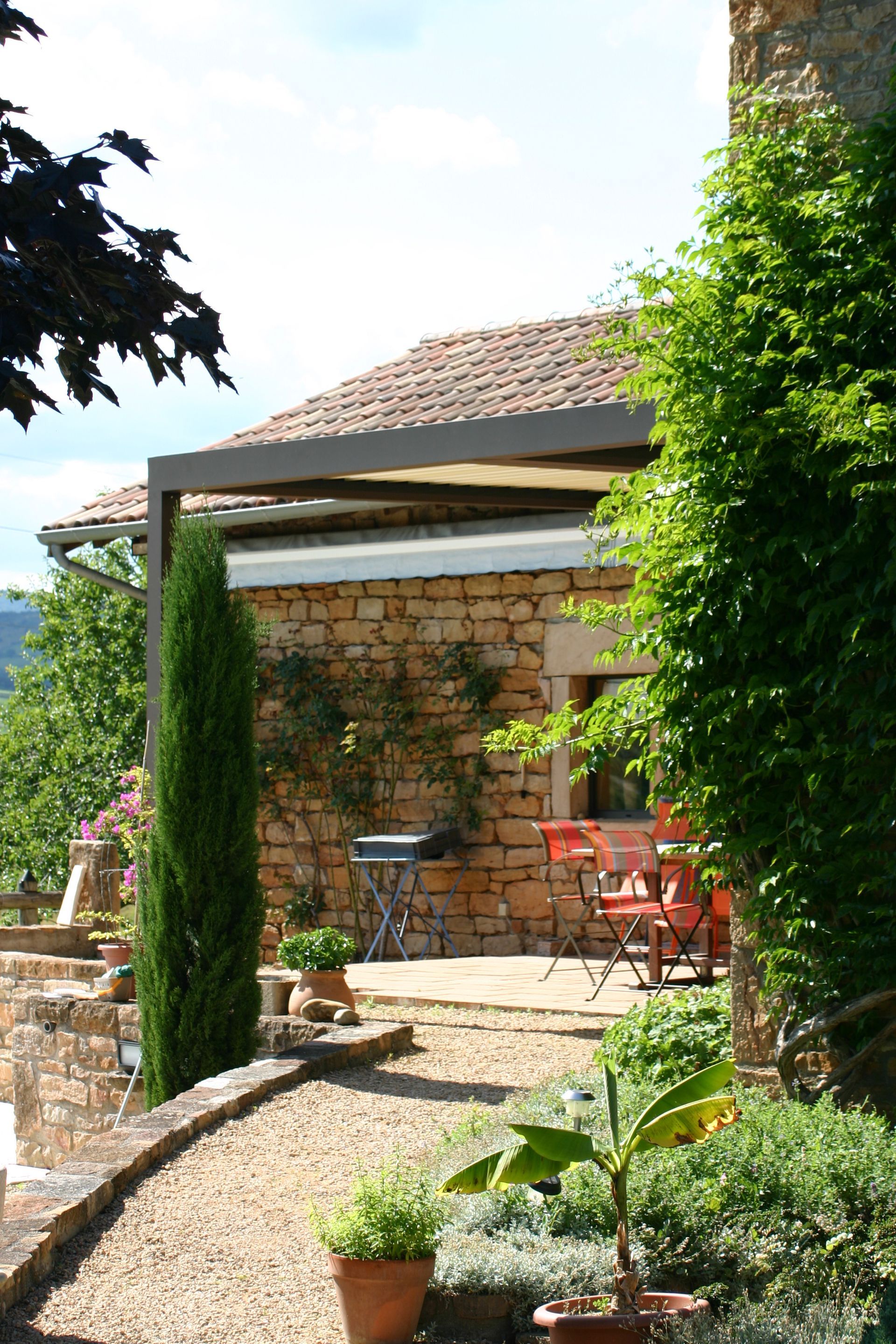 Angle d'une pergola d'une maison à proximité d'arbustes