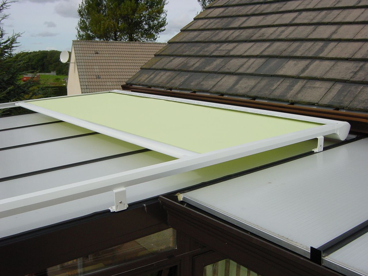 Store de véranda à moitié ouvert couleur vert clair acidulé 