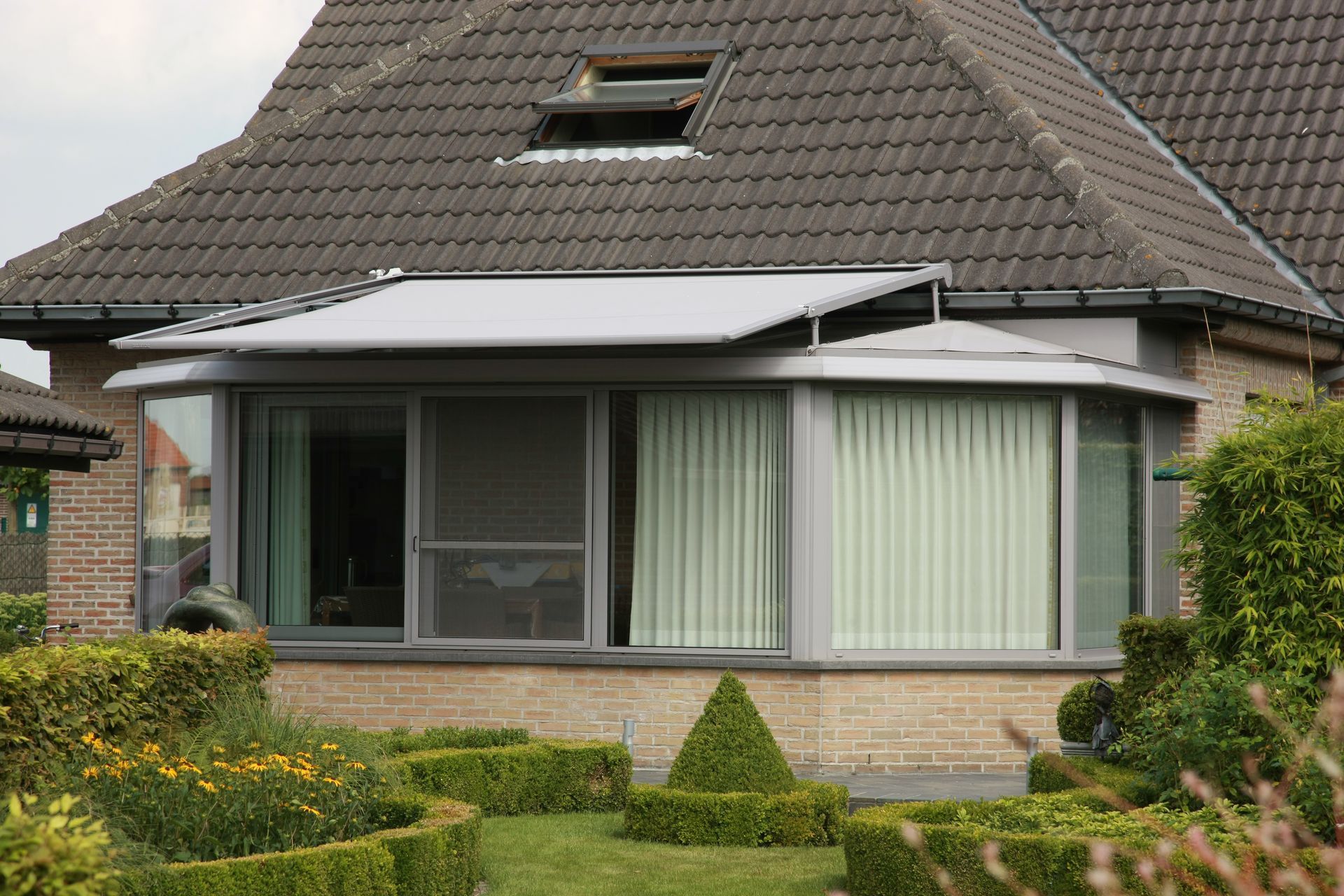 Véranda d'une maison aux rideaux intérieurs de couleurs vert pastel