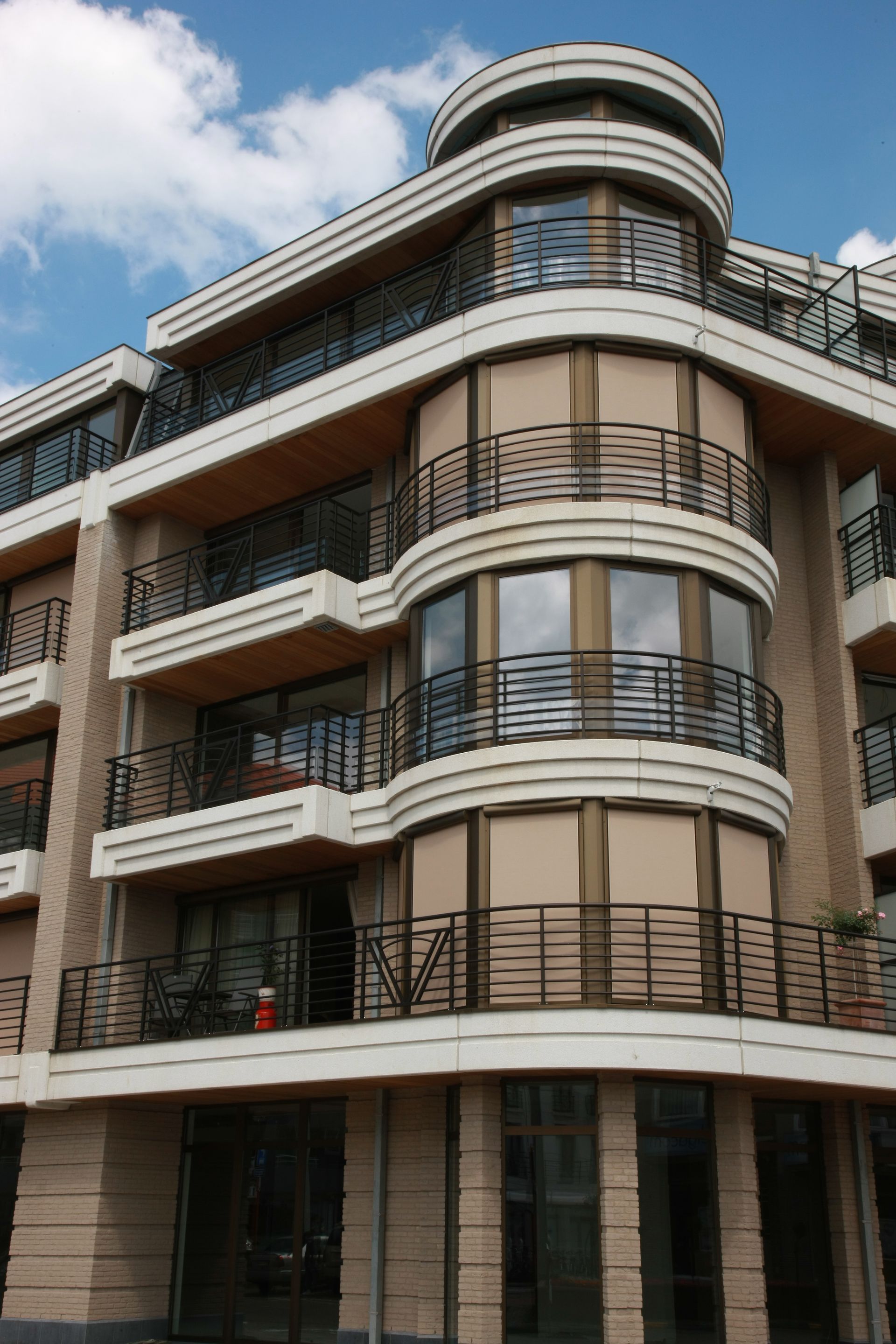 Grand immeuble de plusieurs étages dont certaines fenêtres ont les stores extérieurs fermés