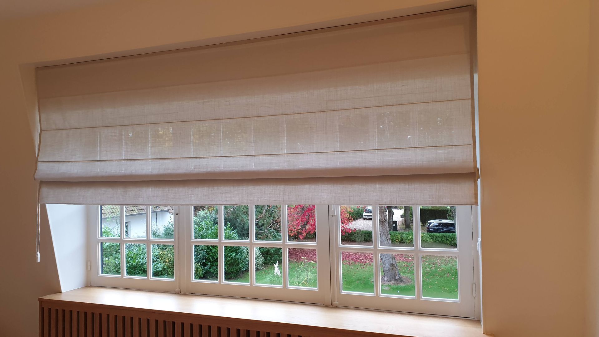 Store en tissu devant une fenêtre à moitié enroulé