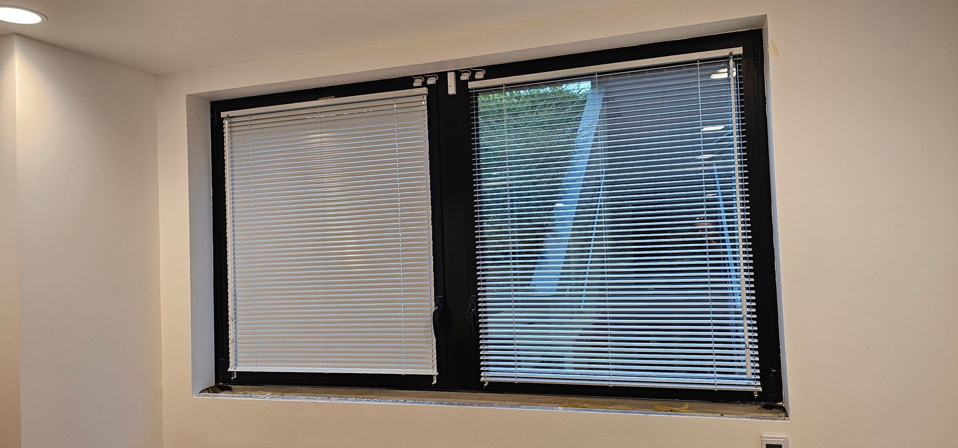 Store à lames sur une fenêtre à double battant