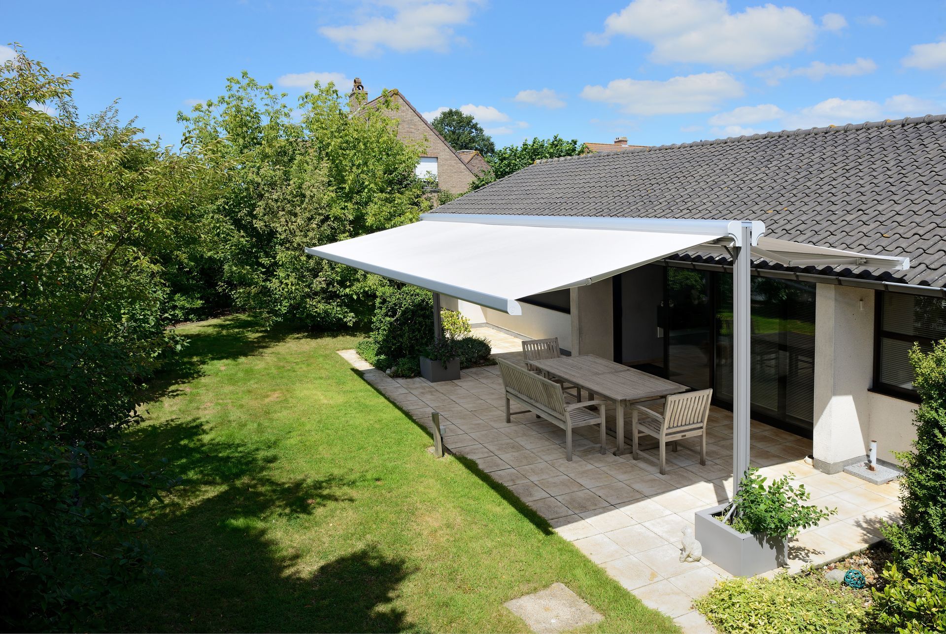Store banne à double pente sur une terrasse de jardin