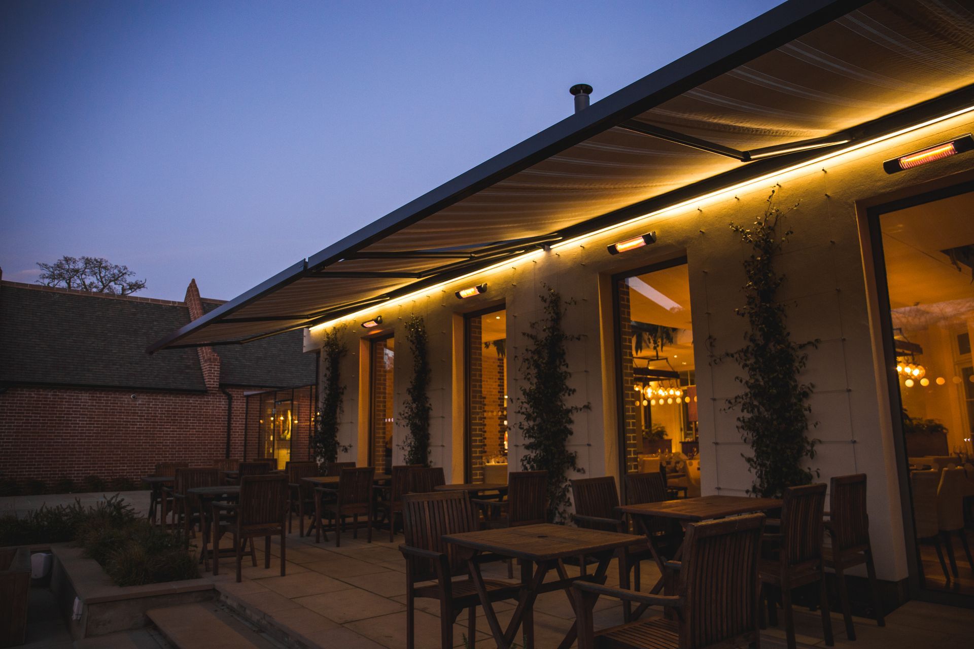 Stores bannes éclairés sur une terrasse de restaurant le soir
