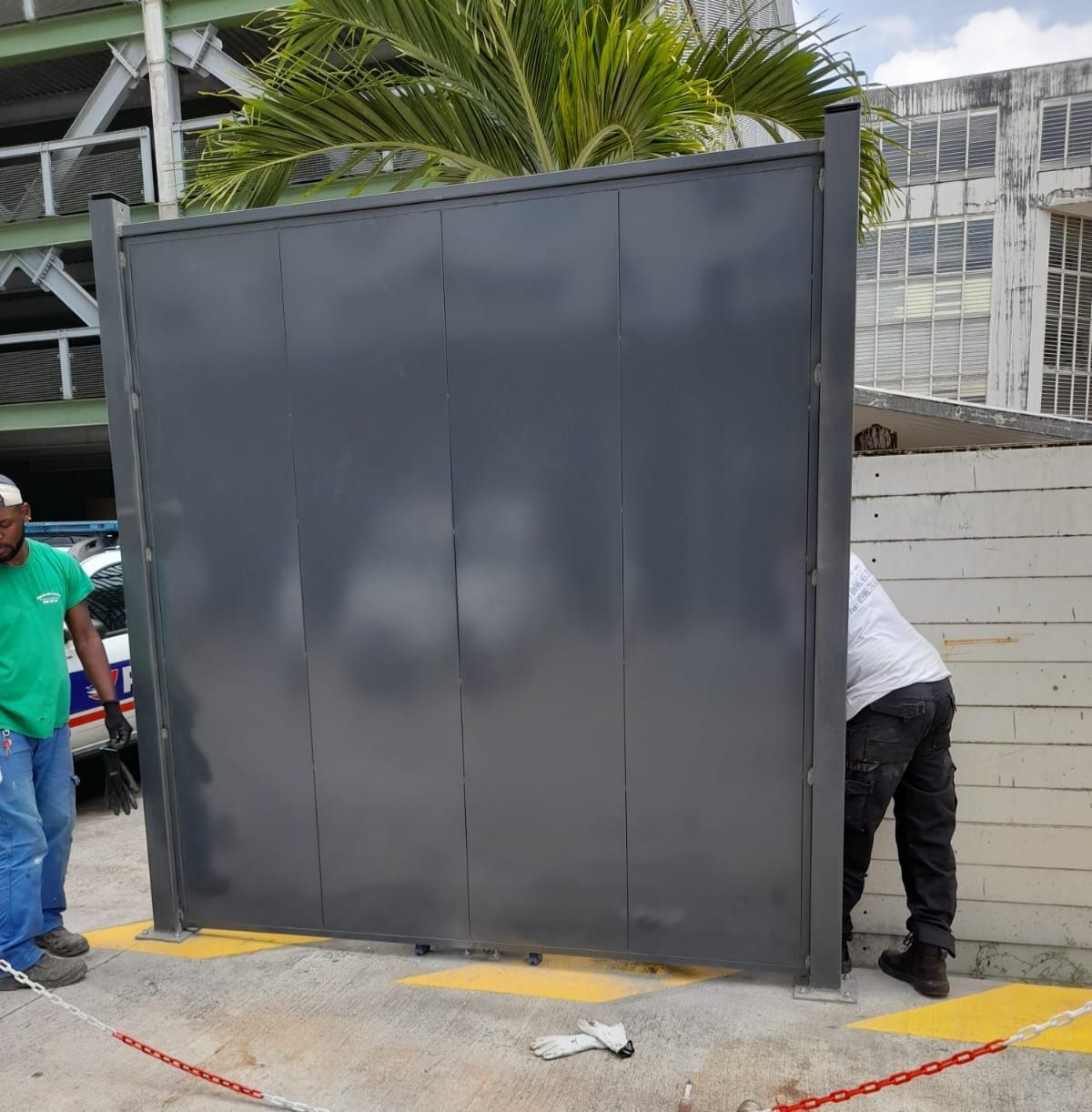 Portail métallique avec des artisans à côté