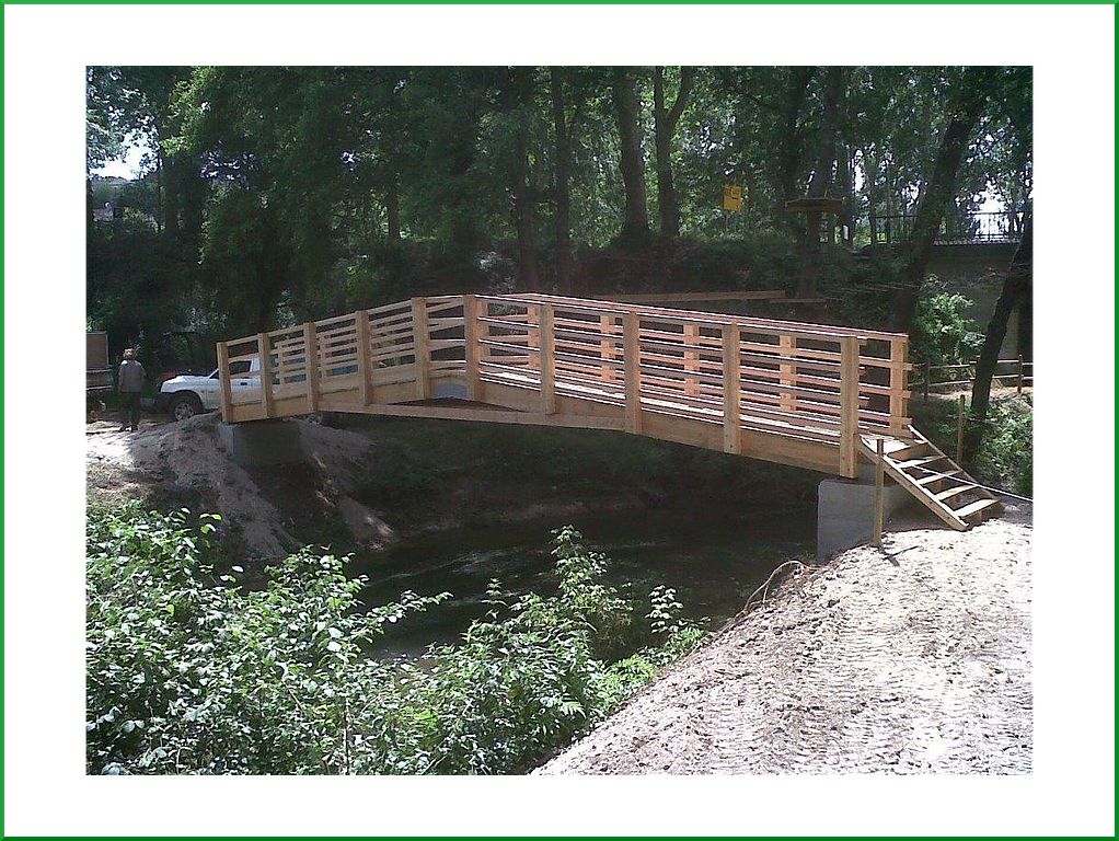 Passerelles en bois et en pierres dans une forêt au-dessus d'un cours d'eau