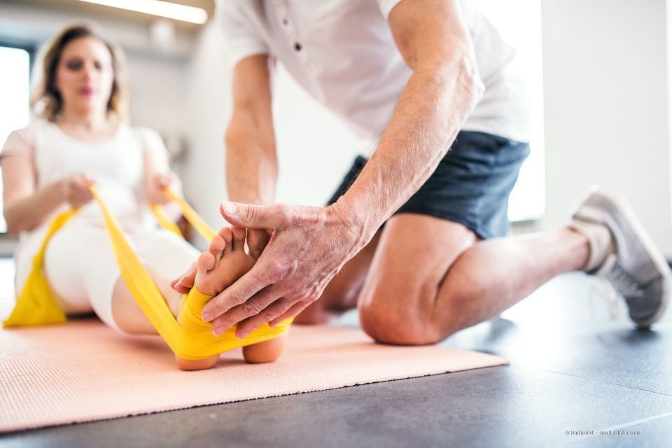Eine Frau erhält in einem geschlossenen Raum Physiotherapie für die Schulter von einer medizinischen Fachkraft.