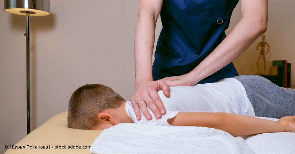 Eine Person massiert ein Kind, das auf einer Massageliege liegt.