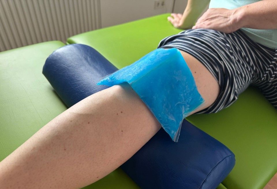 Das Handgelenk einer Person wird einer Kryotherapie unterzogen. Blaue Handschuhe halten ein Metallgerät,