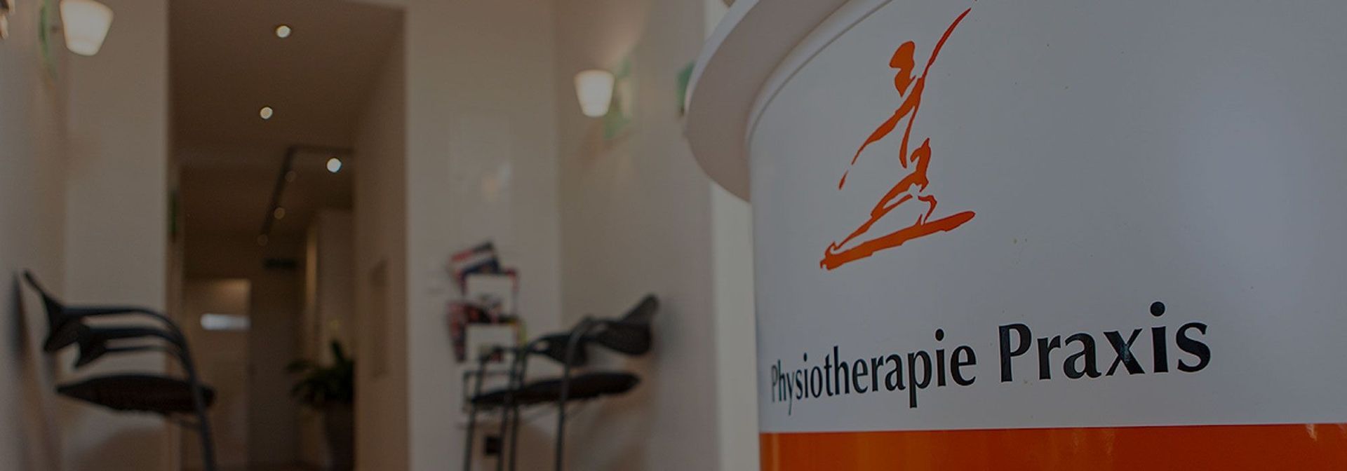 In einer Physiotherapiepraxis liegt der Fokus auf dem Logo eines Containers mit der Aufschrift „Physiotherapie Praxis“.