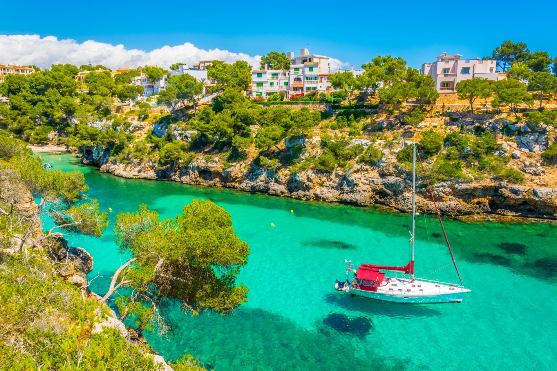 Un velero flota sobre un lago turquesa.