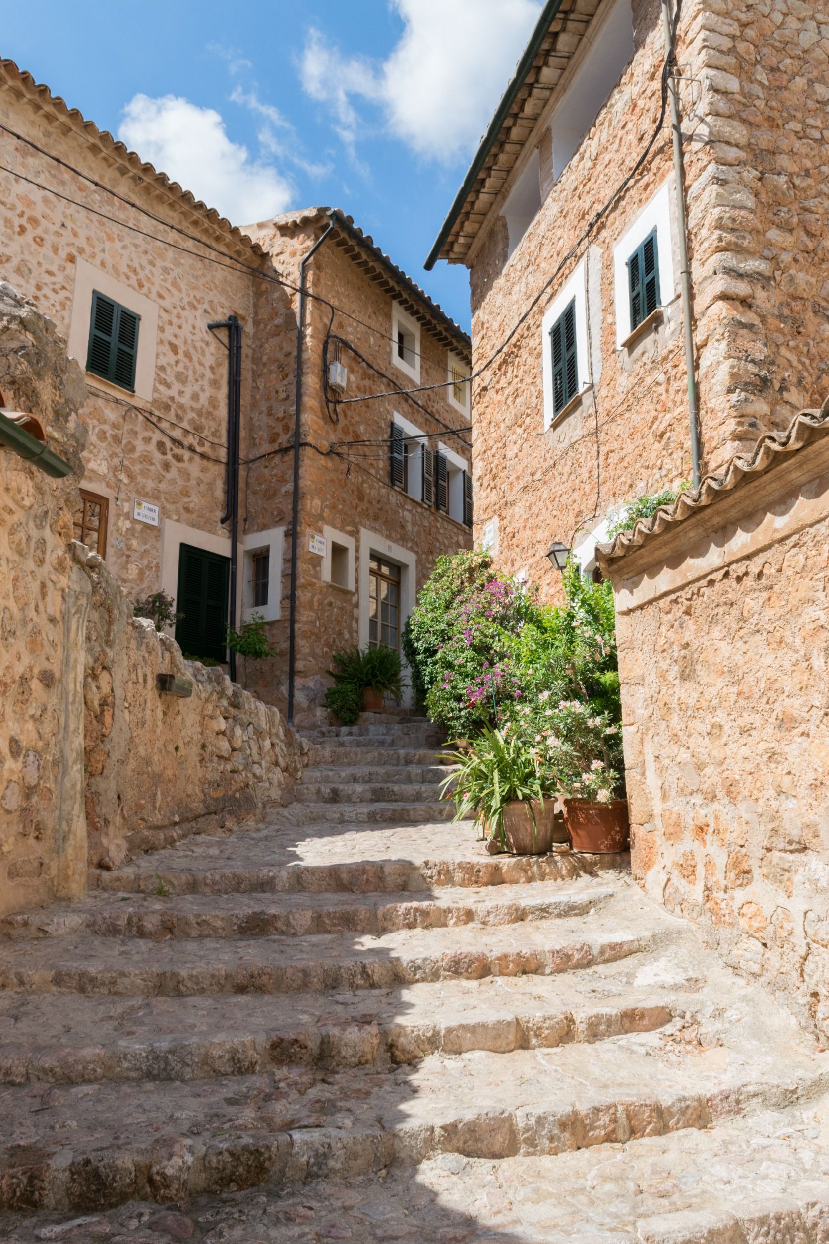 Un callejón estrecho con escaleras entre dos edificios de ladrillo.