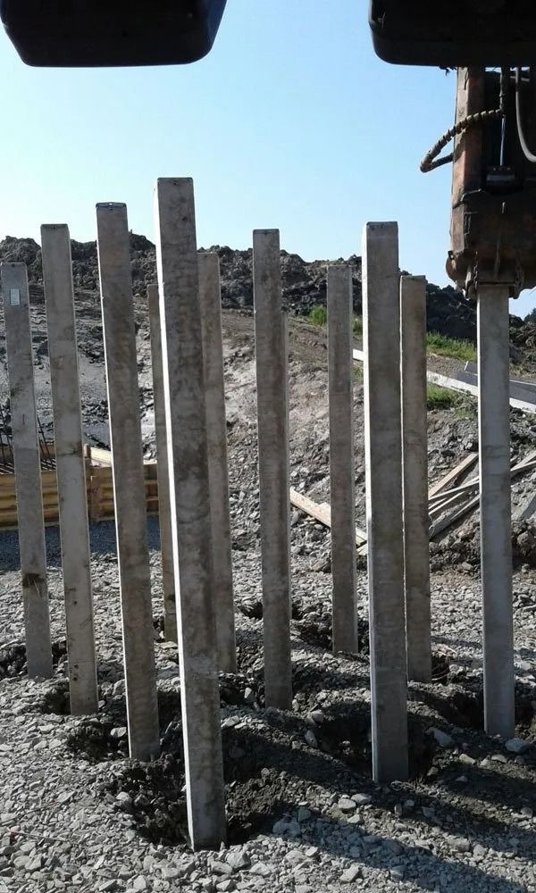 Betoniaidan tolpat sorassa rakennustyömaalla kirkkaan taivaan alla