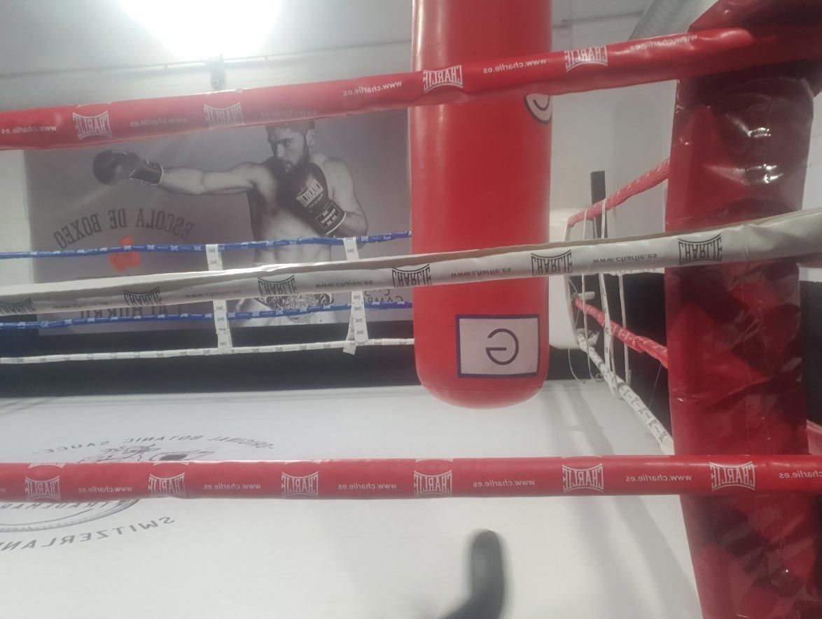 Un ring de boxeo con una bolsa roja en el medio