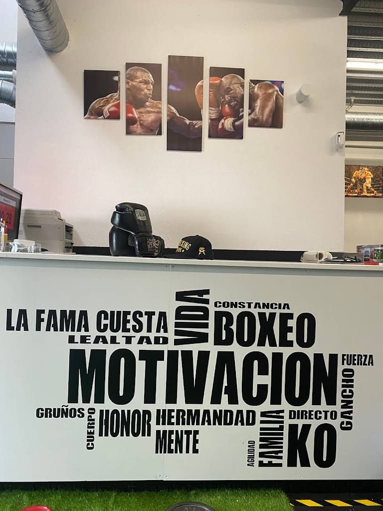 Un gimnasio de boxeo con un cartel que dice la fama cuesta boxeo
