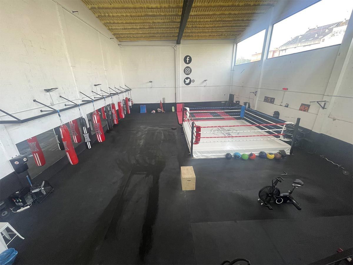 Hay un ring de boxeo en el medio del gimnasio.