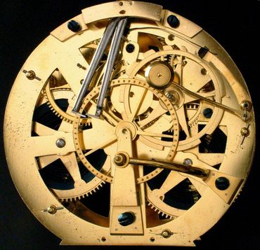 Gros plan sur le mouvement d'une horloge mécanique en or, laissant apparaître les engrenages et les ressorts.