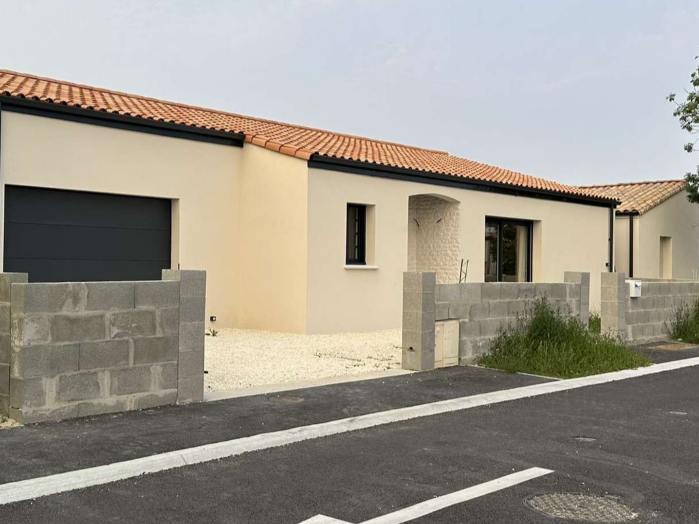 Un ouvrier du bâtiment travaille sur un coffrage en béton, une brouette à proximité.