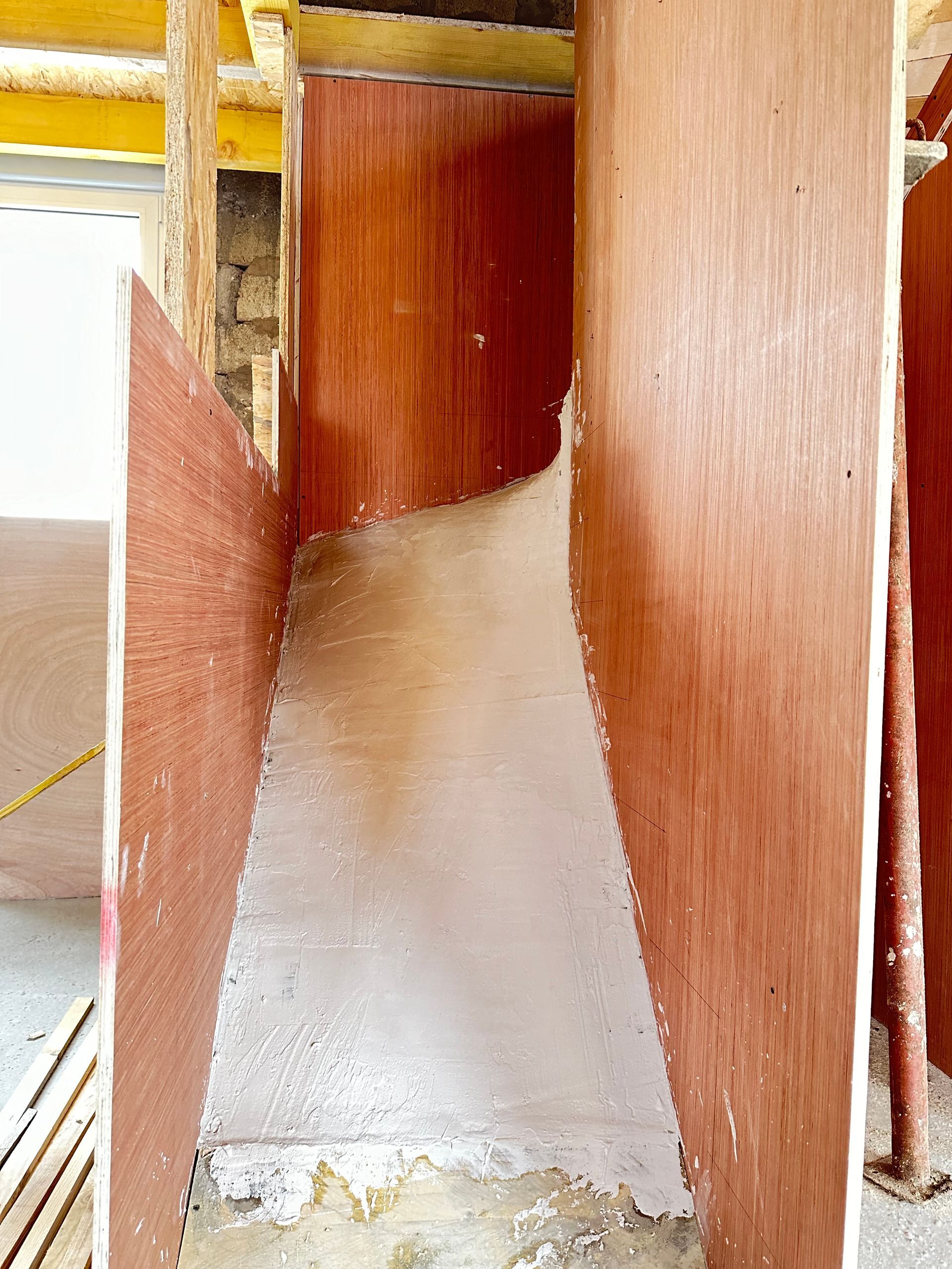 Coffrage en bois pour coulage de béton, avec résidus de béton visibles.