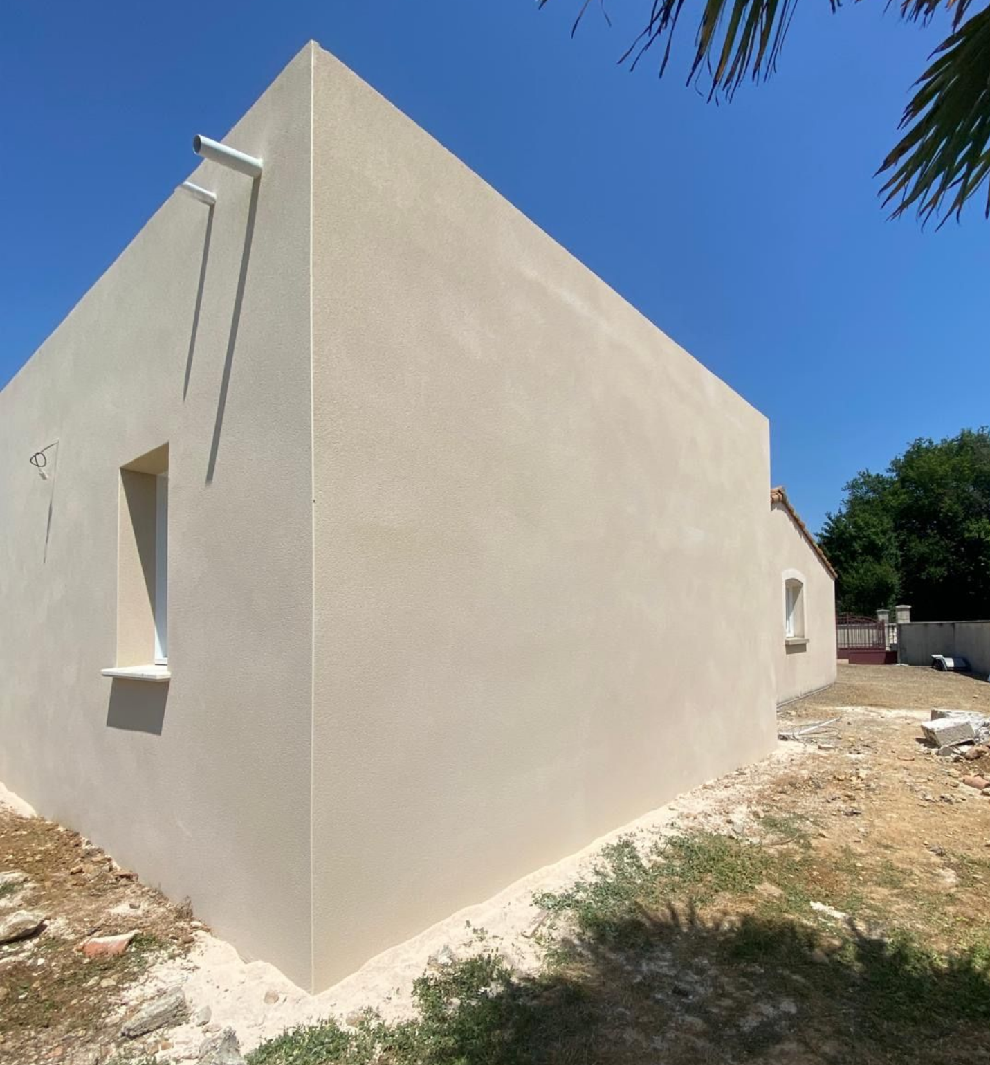 Extérieur d'un bâtiment en construction, montrant la maçonnerie, l'isolation et les échafaudages.