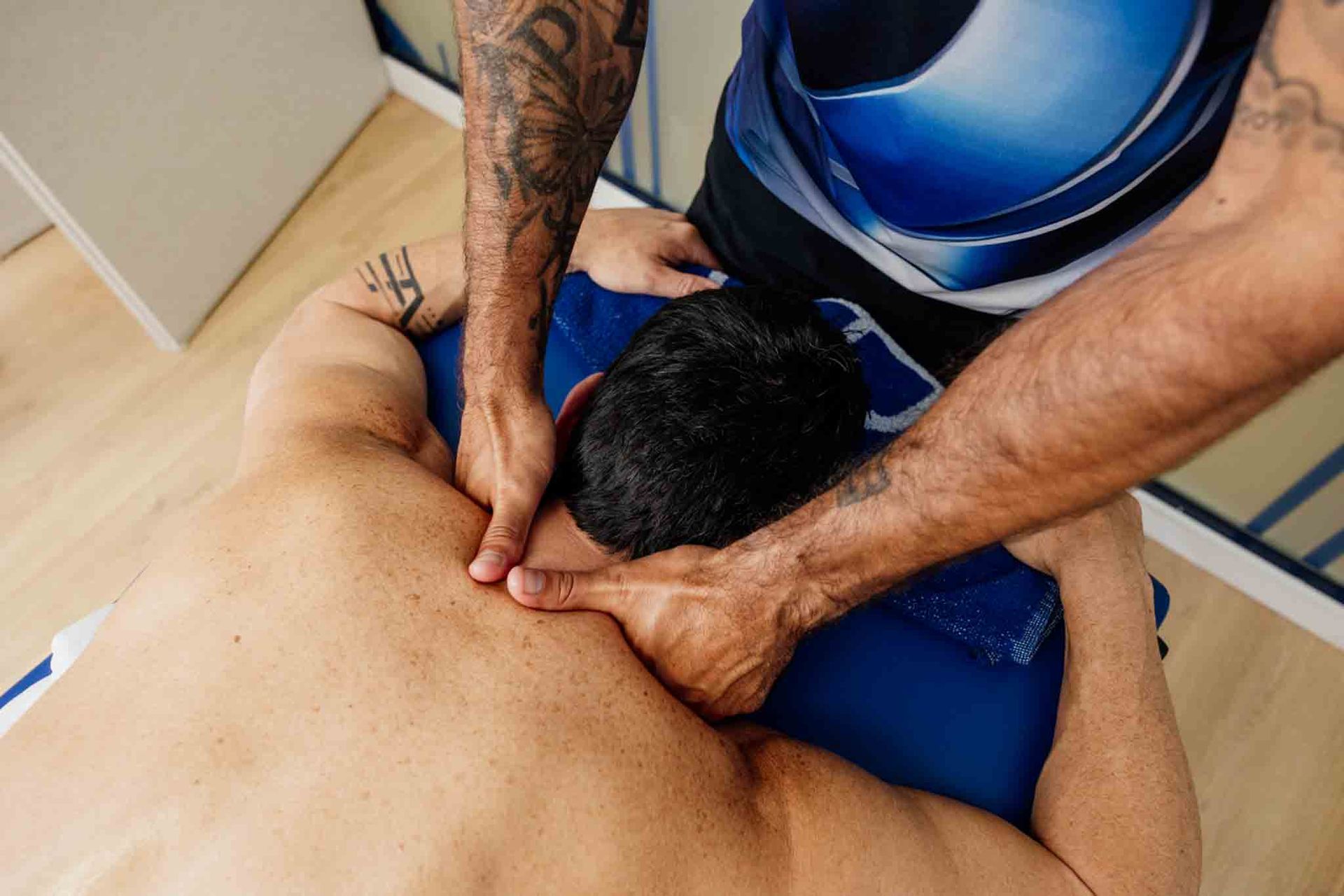 Hombre recibe un masaje de espalda, con especial atención al cuello y los hombros.