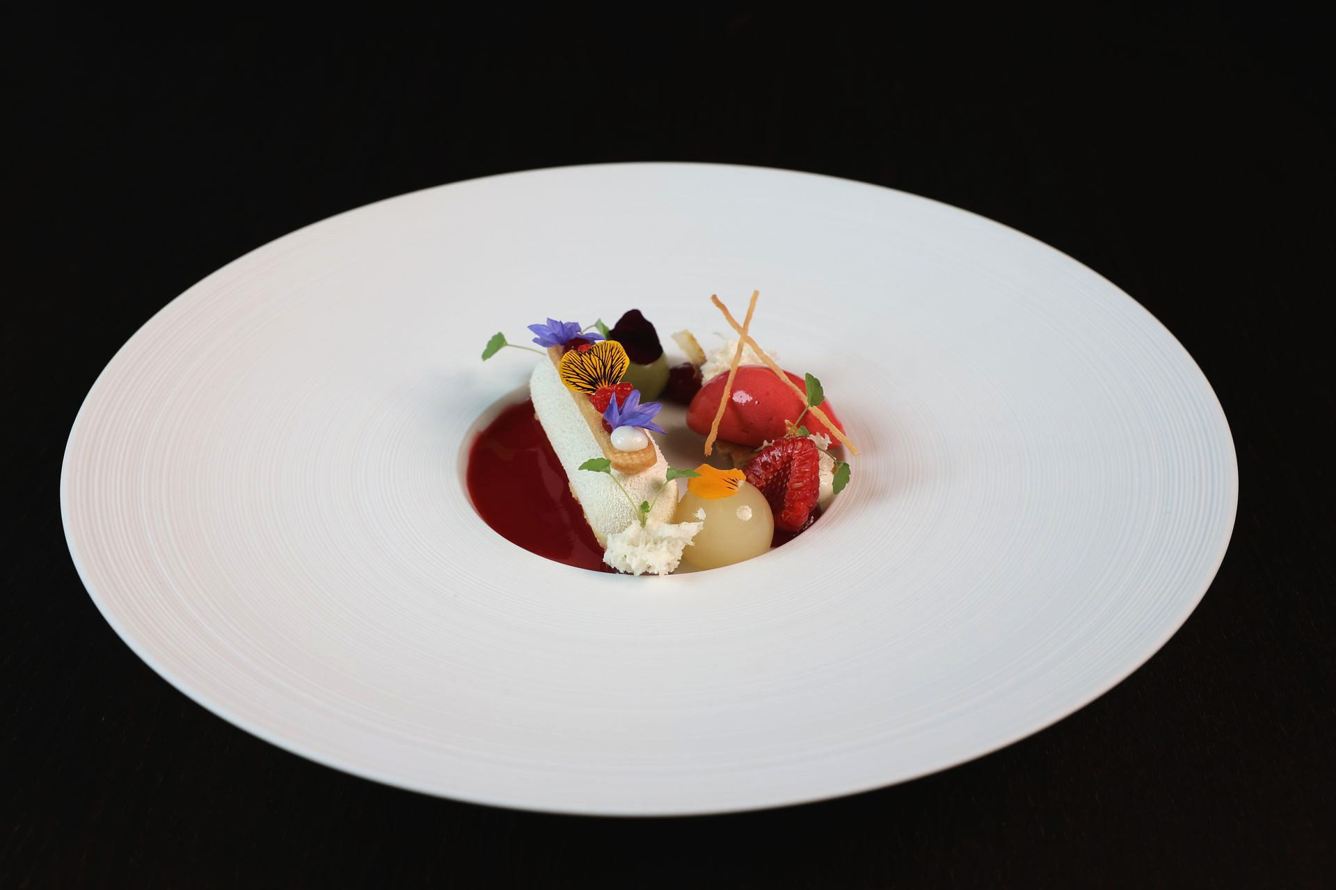 Ein weißer Teller mit einem Schokoladendessert und Erdbeeren