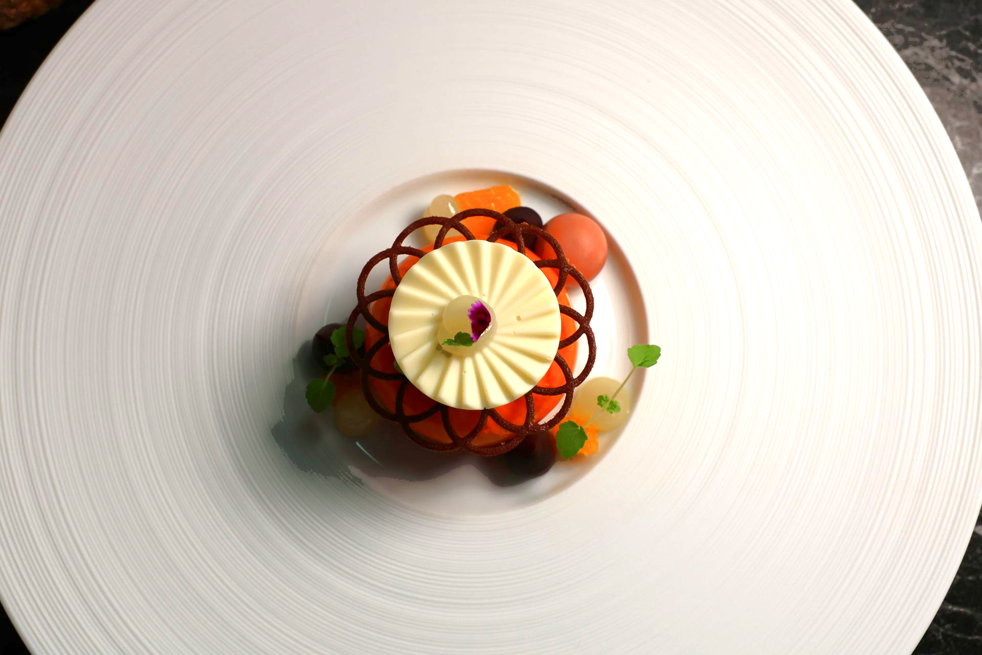 Eine schwarze Schüssel gefüllt mit Essen und Blumen auf einem Tisch