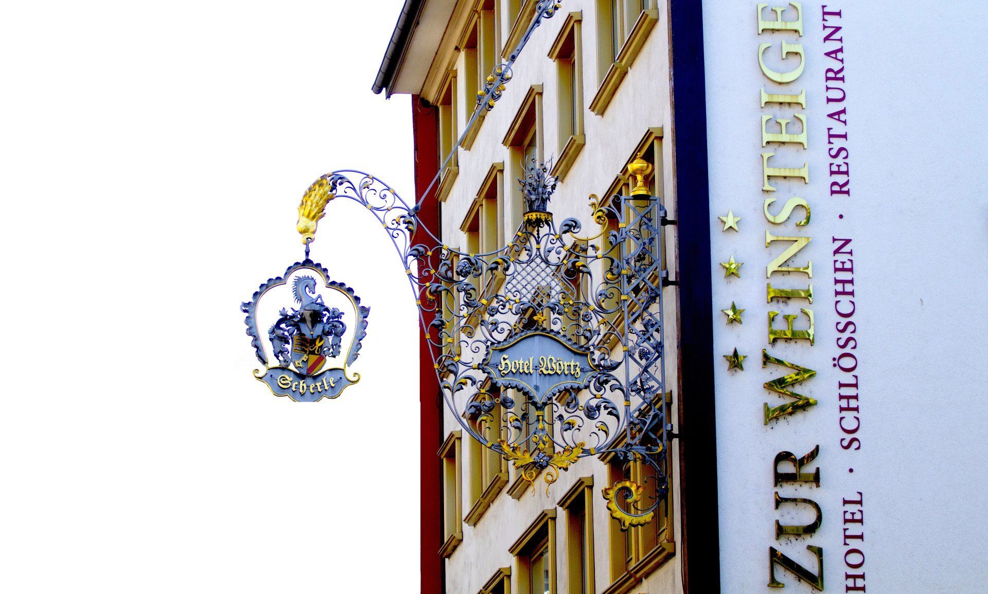 Ein Schild an der Seite eines Gebäudes mit der Aufschrift „Zur Weinstraße“