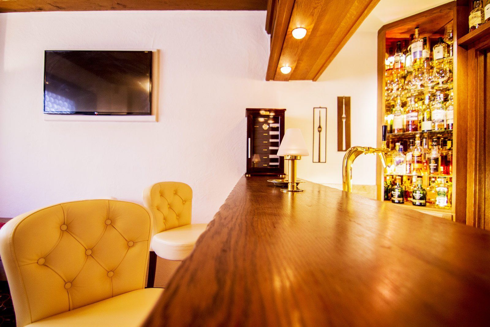 Eine Bar mit zwei Stühlen und einem Flachbildfernseher