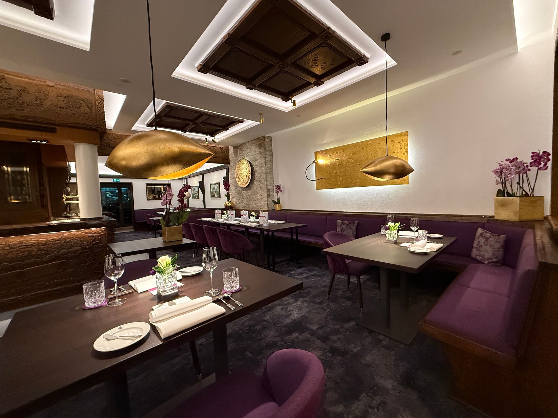 Ein Restaurant mit lila Stühlen und Tischen und einer Uhr an der Wand