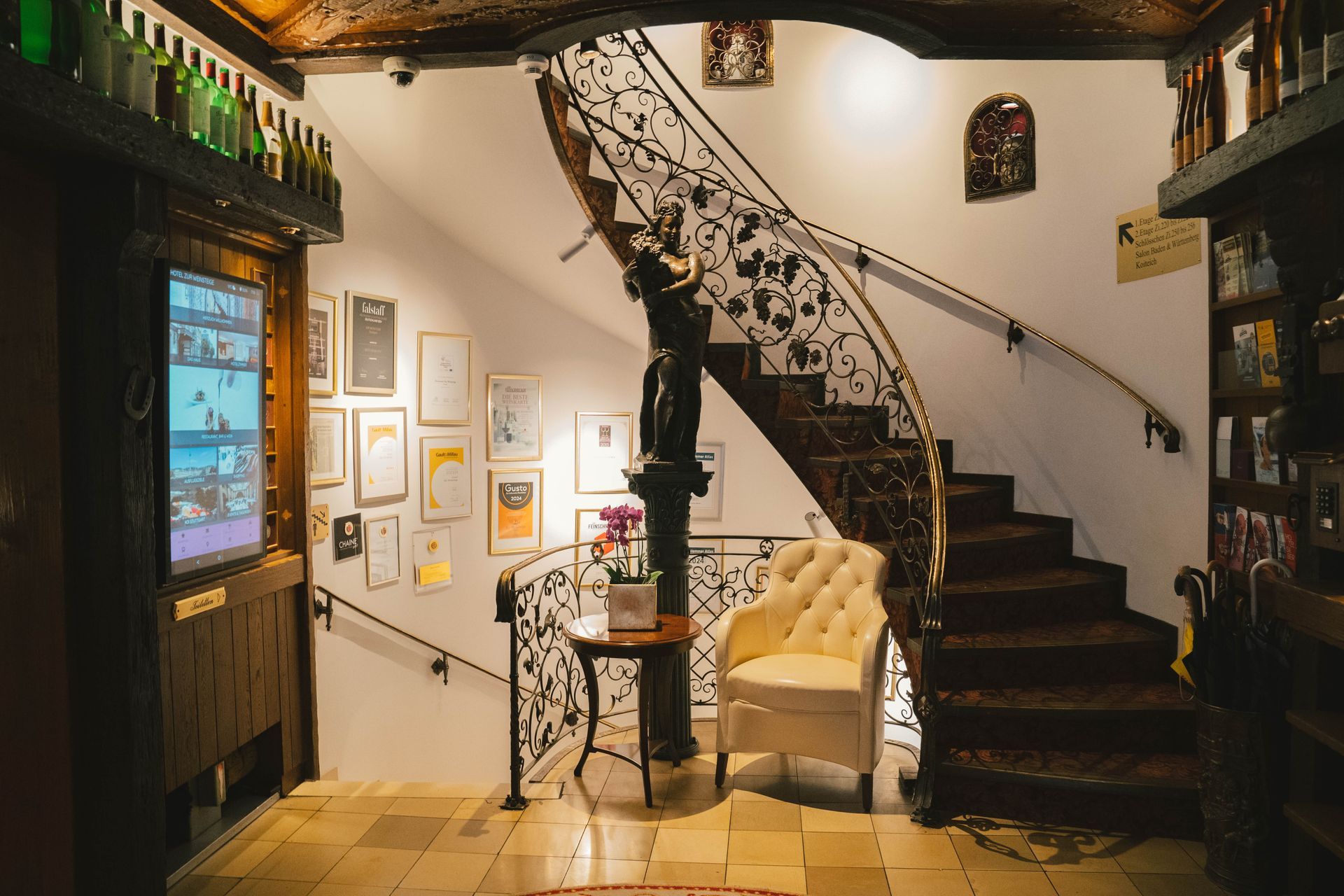 Eine Wendeltreppe mit schmiedeeisernem Geländer und einer Statue