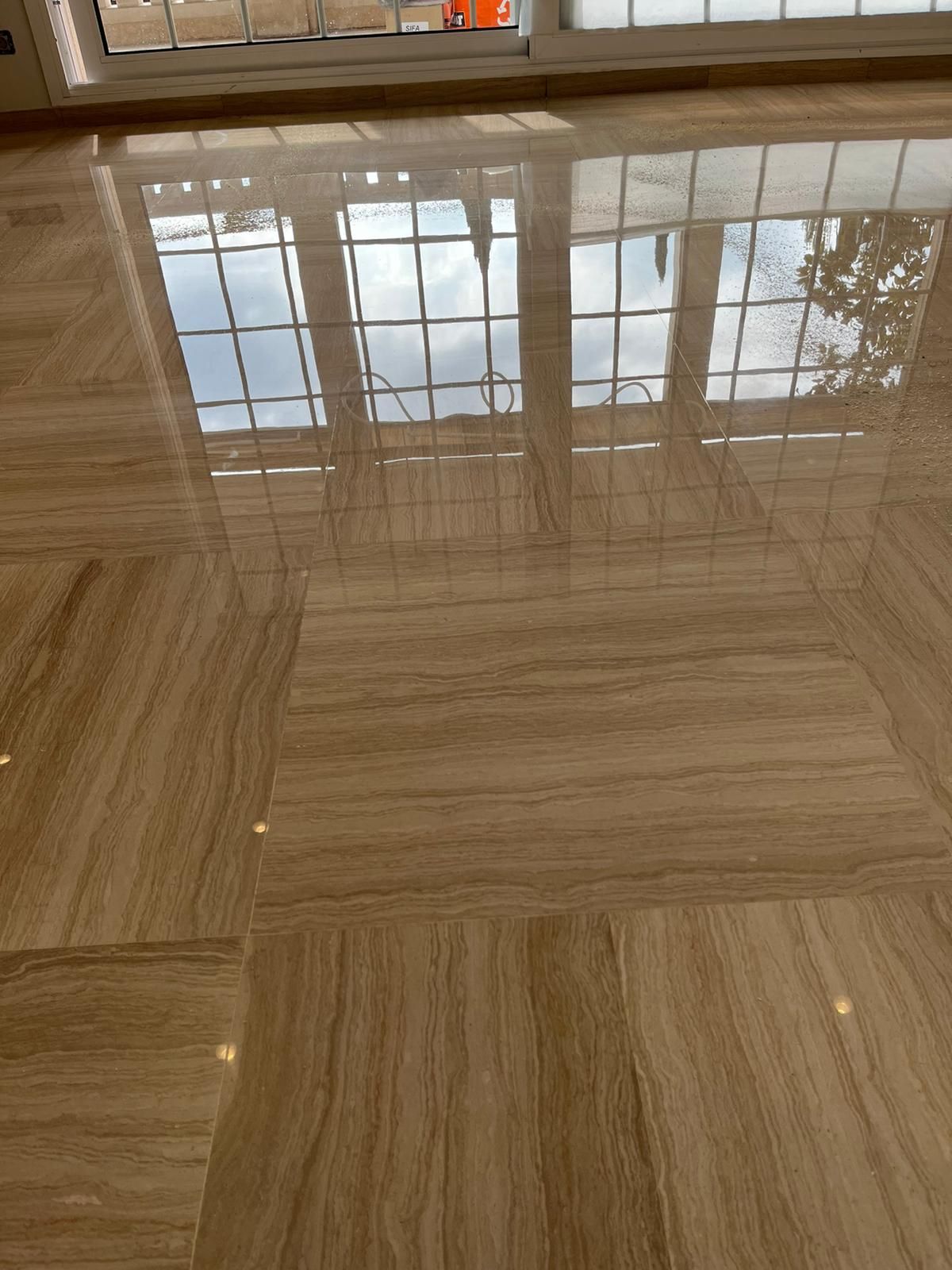 Un suelo de mármol con el reflejo de una ventana.