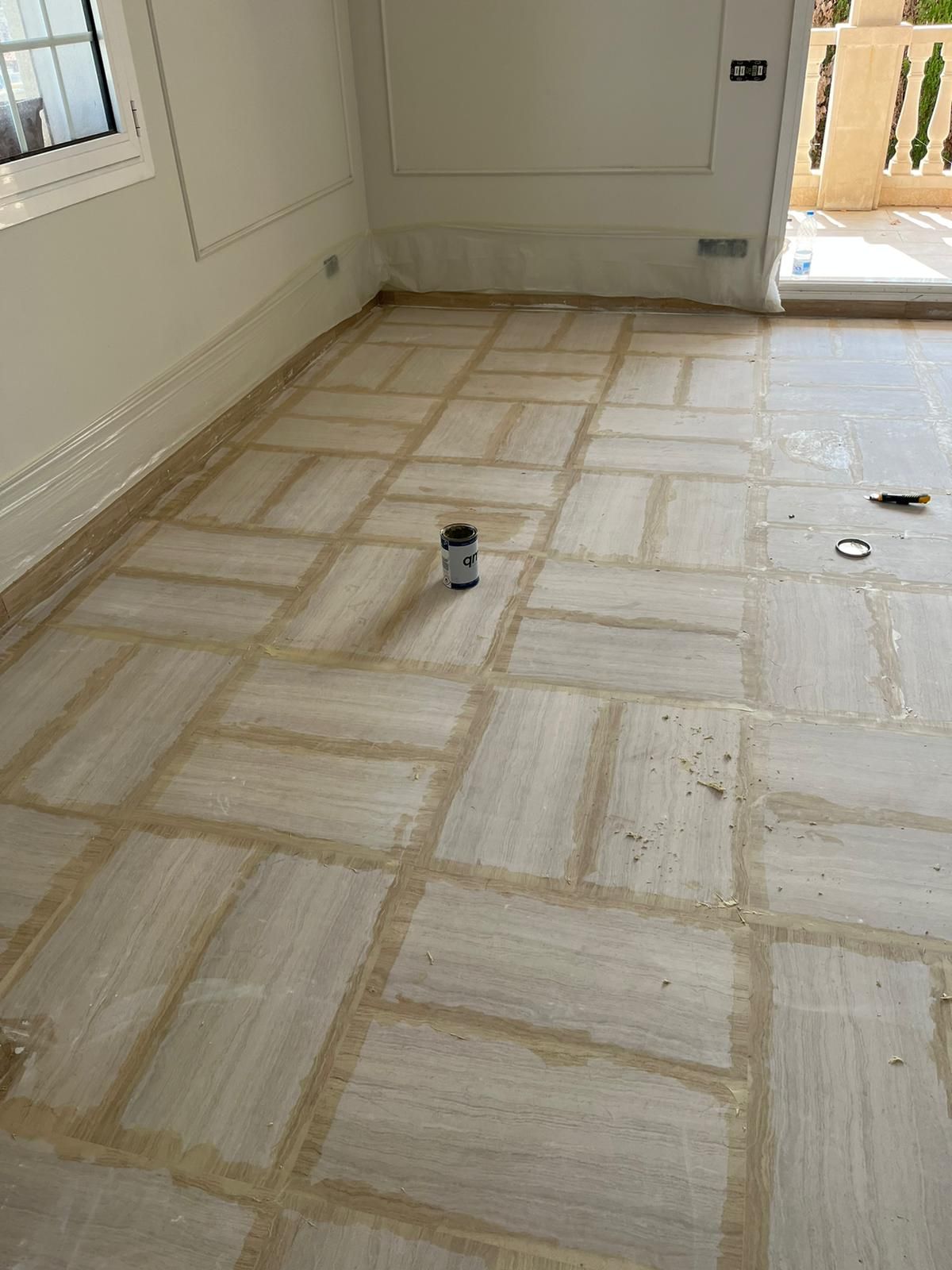 Una habitación con suelo de baldosas y un cubo en el suelo.