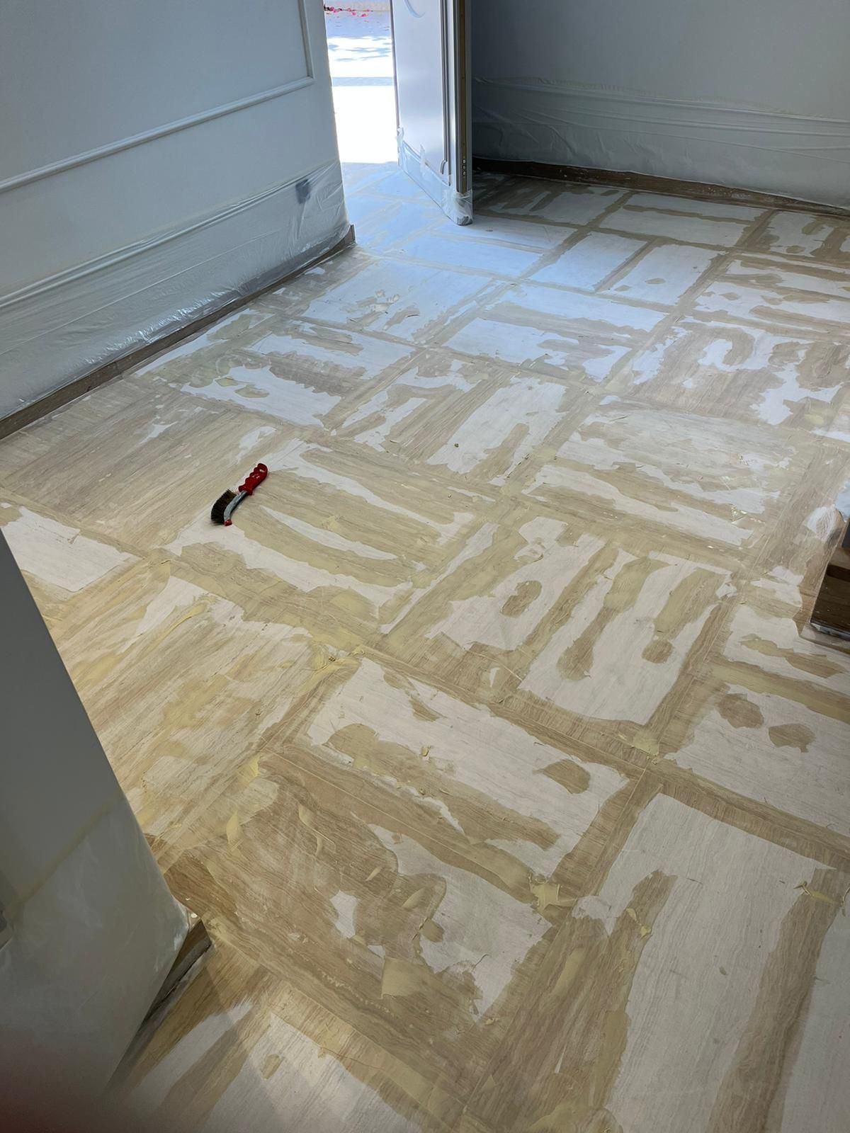 Se está pintando un piso de madera en una habitación.