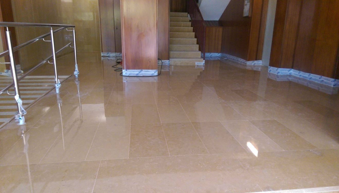 Un vestíbulo con escalera y suelo de mármol.